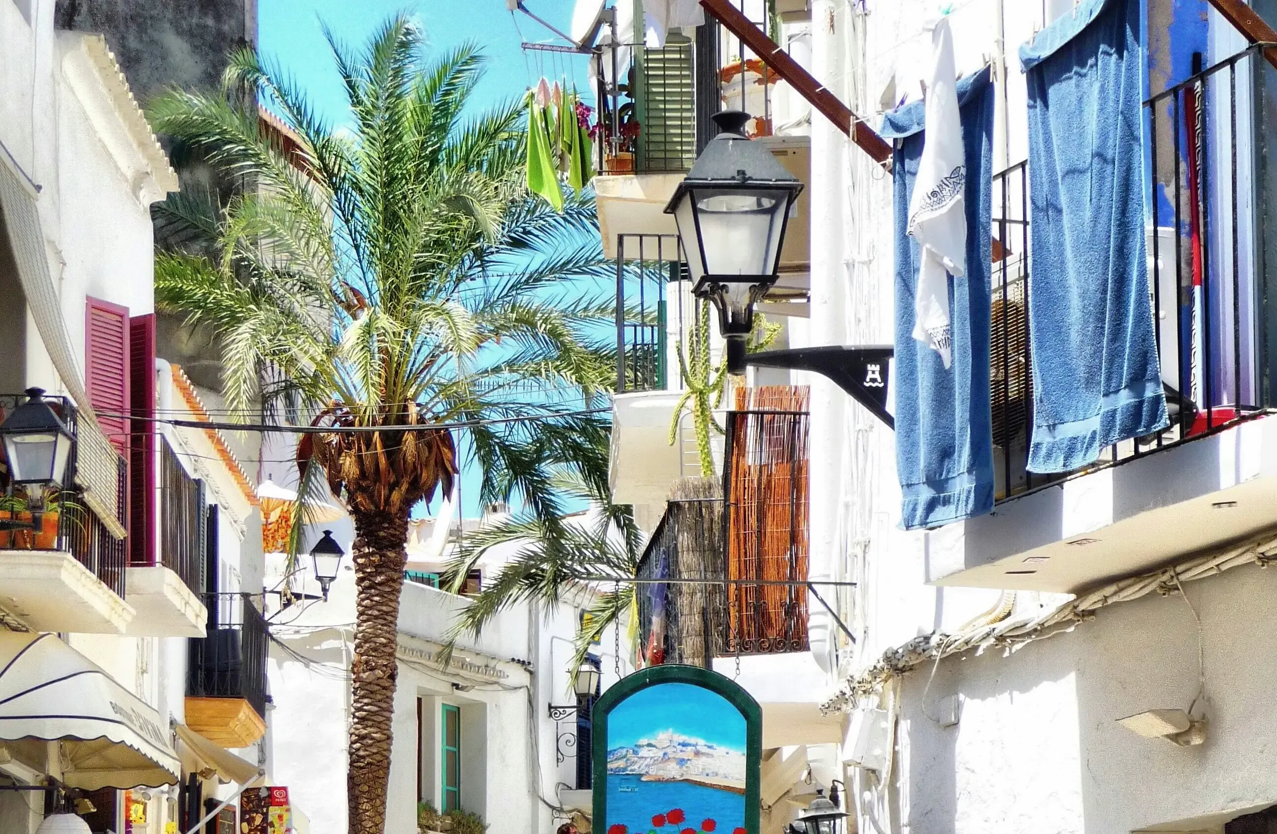 Vue panoramique d'une plage d'Ibiza au coucher du soleil avec des eaux cristallines et des formations rocheuses